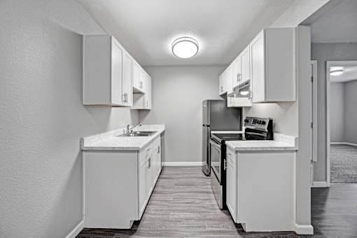 A kitchen with white cabinets and appliances at The Henley Apartments, Suisun City, CA, 94585