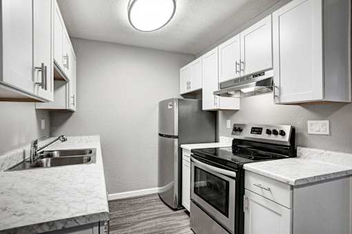 A kitchen with a stove, oven, and sink at The Henley Apartments, Suisun City, California