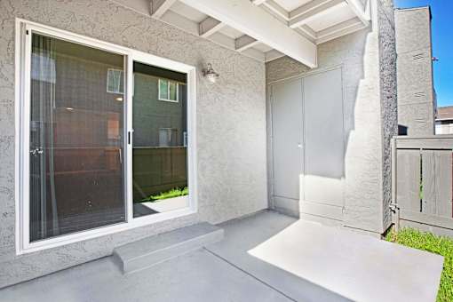 A patio area with a white door and a window at The Henley Apartments, Suisun City