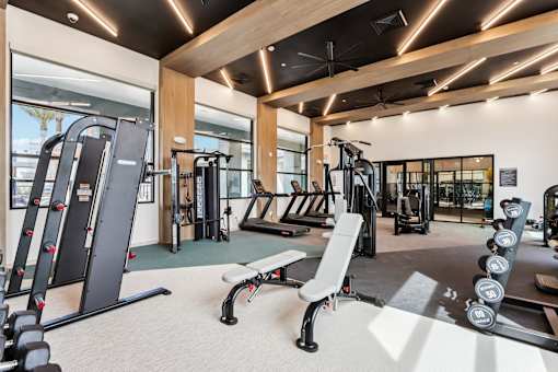 A gym with a variety of equipment including treadmills, weights, and exercise machines at Ironwood Ranch Apartments,Maricopa