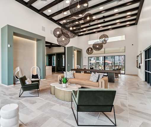 A modern living room with a green chair and a brown couch at Ironwood Ranch Apartments,Maricopa,Arizona