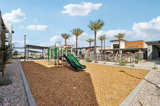 A playground with a green slide and brown mulch at Ironwood Ranch Apartments,Maricopa,AZ,85138