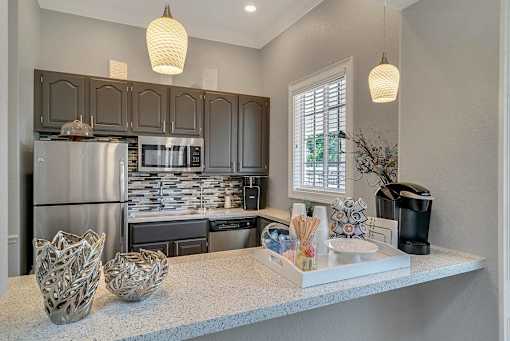 A kitchen with a refrigerator, microwave, and oven at The Villages on Millenia Apartments, Florida, 32839