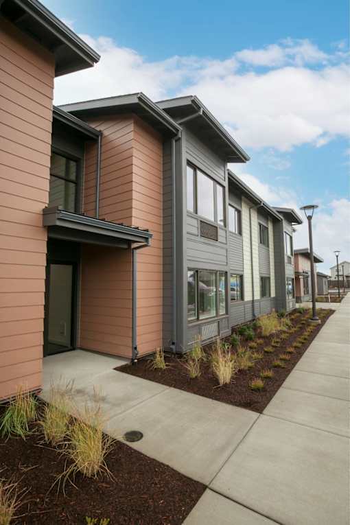 Row of houses with sidewalk at Bridge Meadows Redmond Apartments, Redmond, OR, 97756