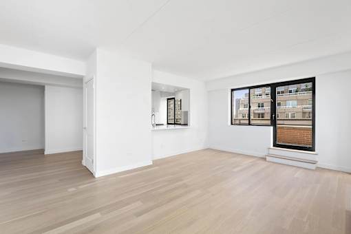A room with a white wall and a wooden floor.