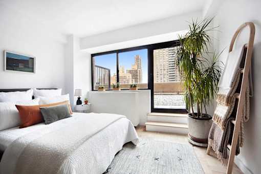 A bedroom with a large bed and a view of the city.