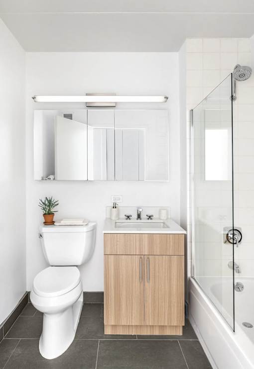 A white toilet sits next to a sink in a modern bathroom.