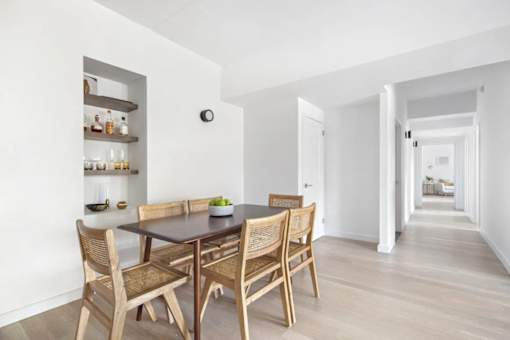 A dining room with a table and chairs.