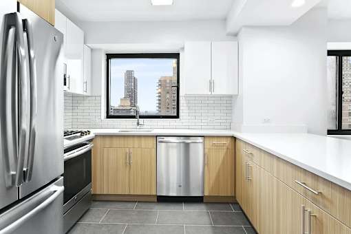 A modern kitchen with wooden cabinets and a stainless steel refrigerator.