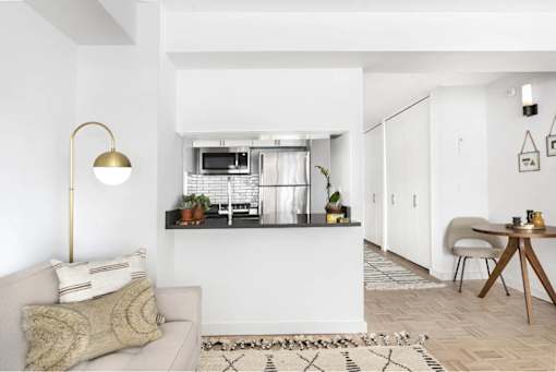 A modern living room with a grey sofa and a wooden table.