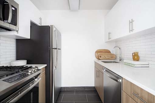 A modern kitchen with black appliances and white cabinets.