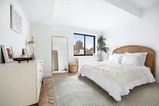 A bedroom with a large bed and a dresser.