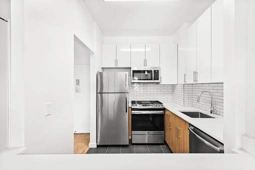 A modern kitchen with a stainless steel refrigerator and oven.