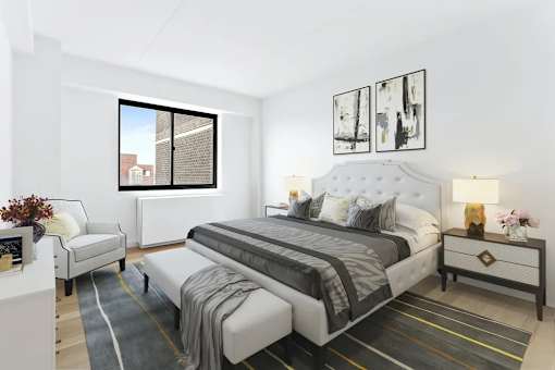 A bedroom with a large bed, a chair, and a window.