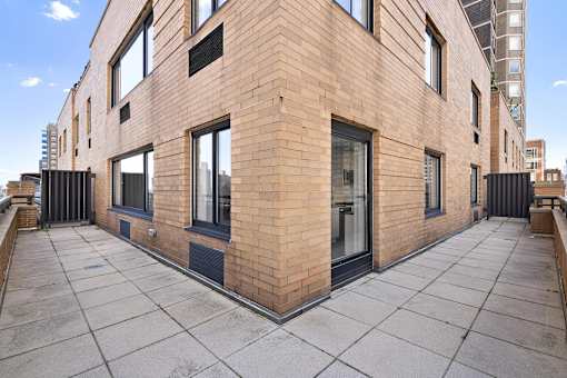 A modern brick building with a flat roof and large windows.