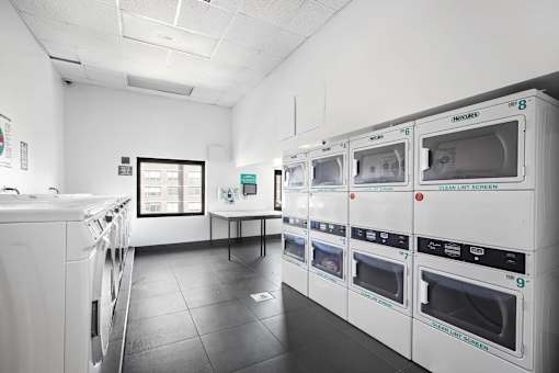 A row of white ovens are lined up in a room.