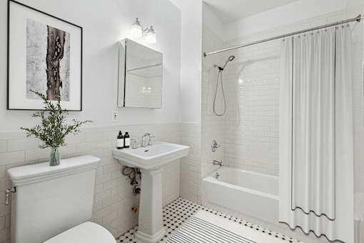 A white bathroom with a sink, toilet, and bathtub.