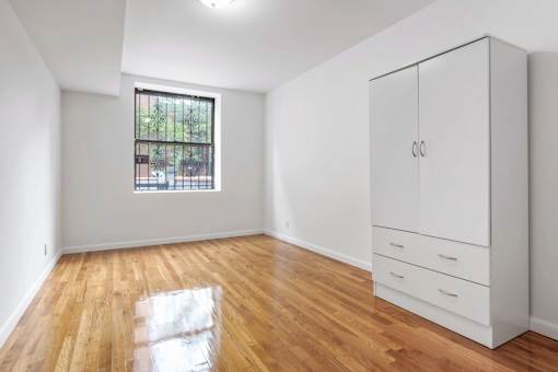 A room with a wooden floor and a white cabinet.