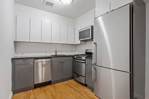 A kitchen with a stainless steel refrigerator, dishwasher, and oven.