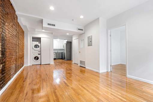 A room with a wooden floor and a brick wall.