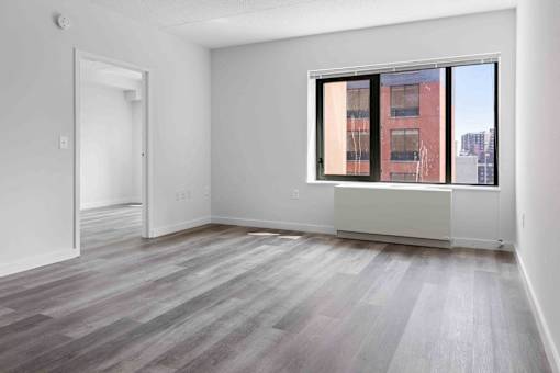 A room with a large window and a wooden floor.