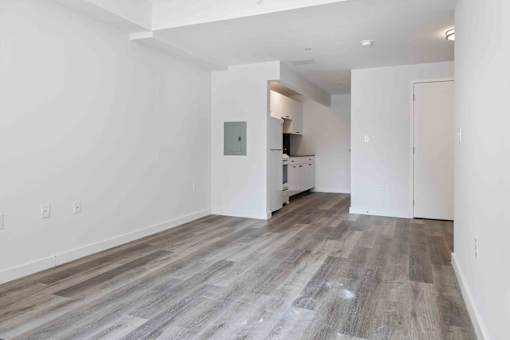A room with wooden flooring and white walls.
