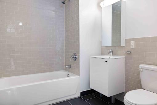 A white bathroom with a tub, toilet, and sink.