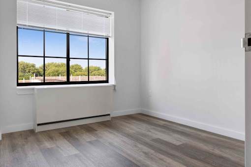 A room with a large window and wooden flooring.