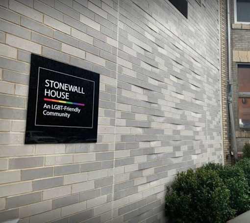 A sign on a building that says Stonewall House an LGBT friendly community.