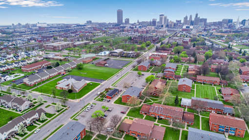 A suburban area with apartment buildings and a city skyline in the background.