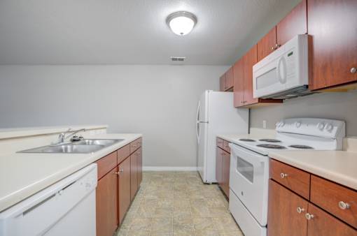 Kitchen with Wooden Cabinets at PALMETTO RIDGE Apartments, TITUSVILLE