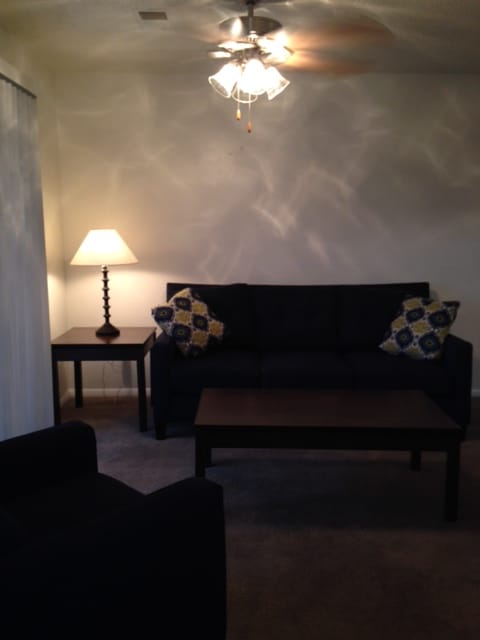 A room with a light on the wall and a curtain hanging.