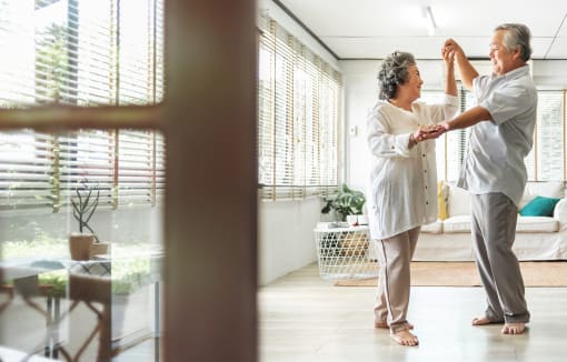 Senior couple in the living room dancing together at DOVER WOODS SENIOR APARTMENTS, Fairfield