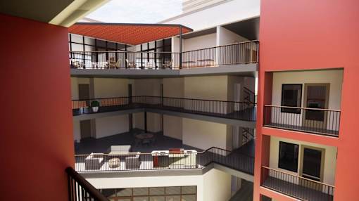 A red and white building with a balcony and a staircase at Vintage at Lockwood Apartments, California