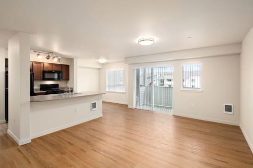 an empty living room and kitchen with wood flooring and a window at COPPER MESA, Reno, NV 89508