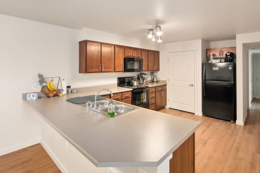 a kitchen with a large island and a black refrigerator at COPPER MESA, Reno, NV