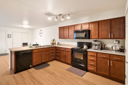 a kitchen with wooden cabinets and a black stove and microwave at COPPER MESA, Reno, 89508