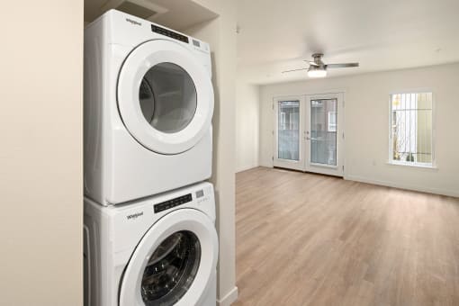 Washer and Dryer in frontview with large hardwood layout in background.