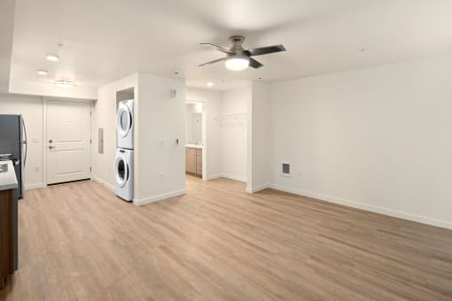 Large floorplan with ceiling fan, washer and dryer and door to bathroom in view