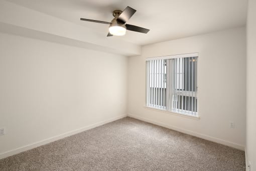 Open bedroom with carpet and ceiling fan