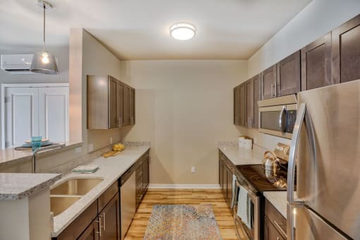 Kitchen with Stainless Steel Appliances, Hardwood Style Flooring, Wood Cabinets, and Overhead Lighting at Salish Flats APARTMENTS, Airway Heights