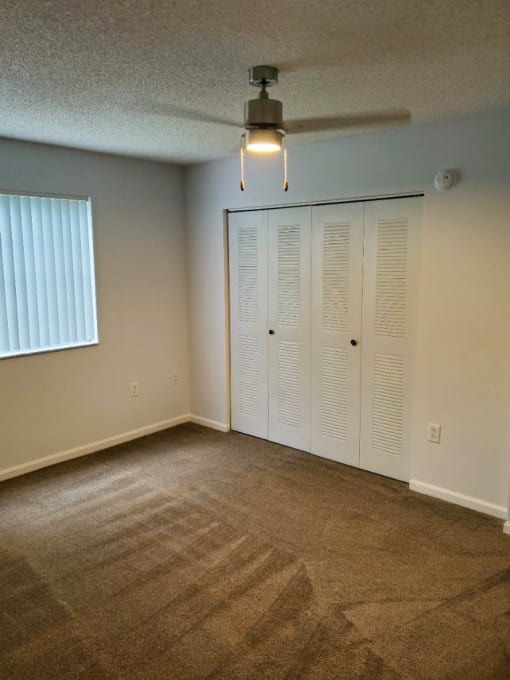 Bedroom with carpeting and ceiling fan at San Marco Apartments, Ormond Beach, Florida