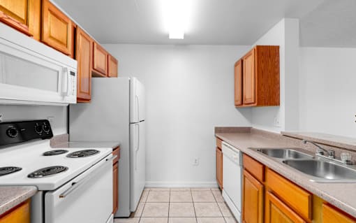 A kitchen with white appliances and wooden cabinets.at Valencia Trace, ORLANDO, 32825