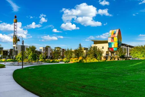 a park with green grass and a large building in the background