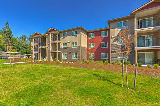 Building exterior and green grounds at SOUTH HILL BY VINTAGE, Puyallup, Washington