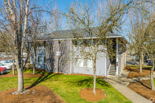 a white house with a gray roof and a green lawn at Township Eastside, Portland, OR