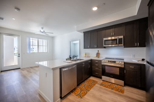 a kitchen with a white counter top and dark cabinets at Vintage at Anacapa Canyon, California 93012