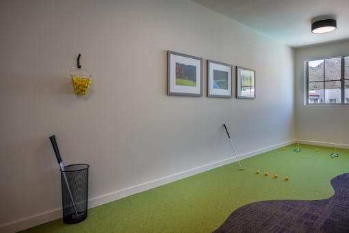 a mini golf room with a basket of balls and pictures on the wall at Vintage at Anacapa Canyon, Camarillo, 93012