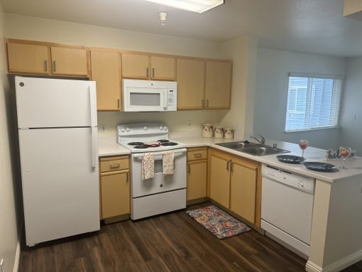 a kitchen with white appliances and wooden cabinets at VINTAGE AT CITI VISTA, Reno, NV