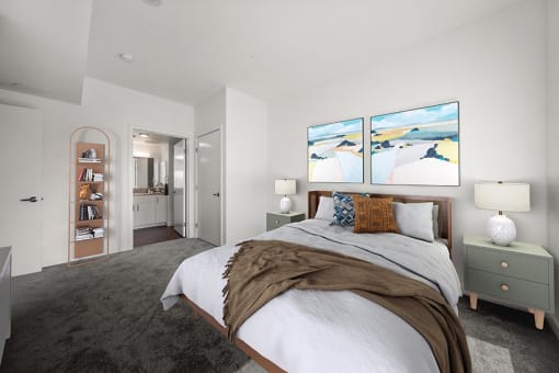 a bedroom with a bed and two paintings on the wall at Grand and Linden Family Apartments, South San Francisco
